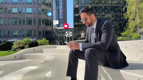 businessman wearing sunglasses sitting outside city offices looking at mobile phone with motion graphics emojis showing multiple messaging and social media notifications