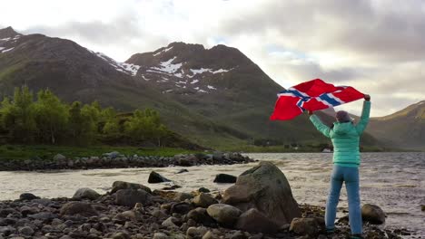 Frau-Mit-Einer-Wehenden-Norwegischen-Flagge-Auf-Dem-Hintergrund-Der-Natur