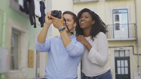 una feliz pareja multirracial tomando fotos de la ciudad vieja.