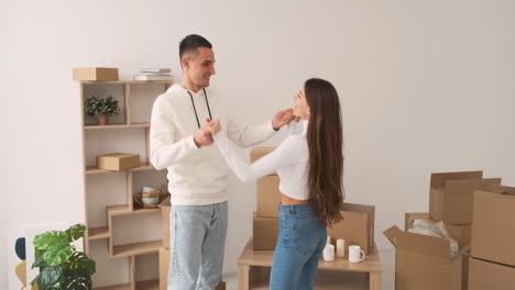 Front-View-Of-A-Young-Happy-Couple-Dancing-Together-In-A-New-House