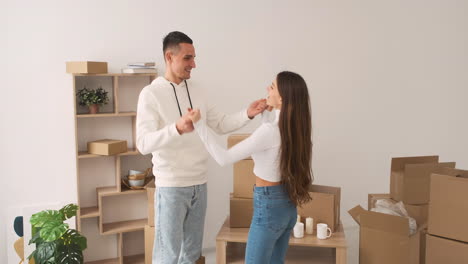 Vista-Frontal-De-Una-Joven-Pareja-Feliz-Bailando-Juntos-En-Una-Casa-Nueva