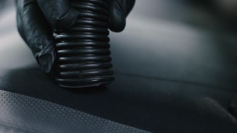 Close-up-of-a-male-wearing-black-gloves-vacuum-an-black-interior-car