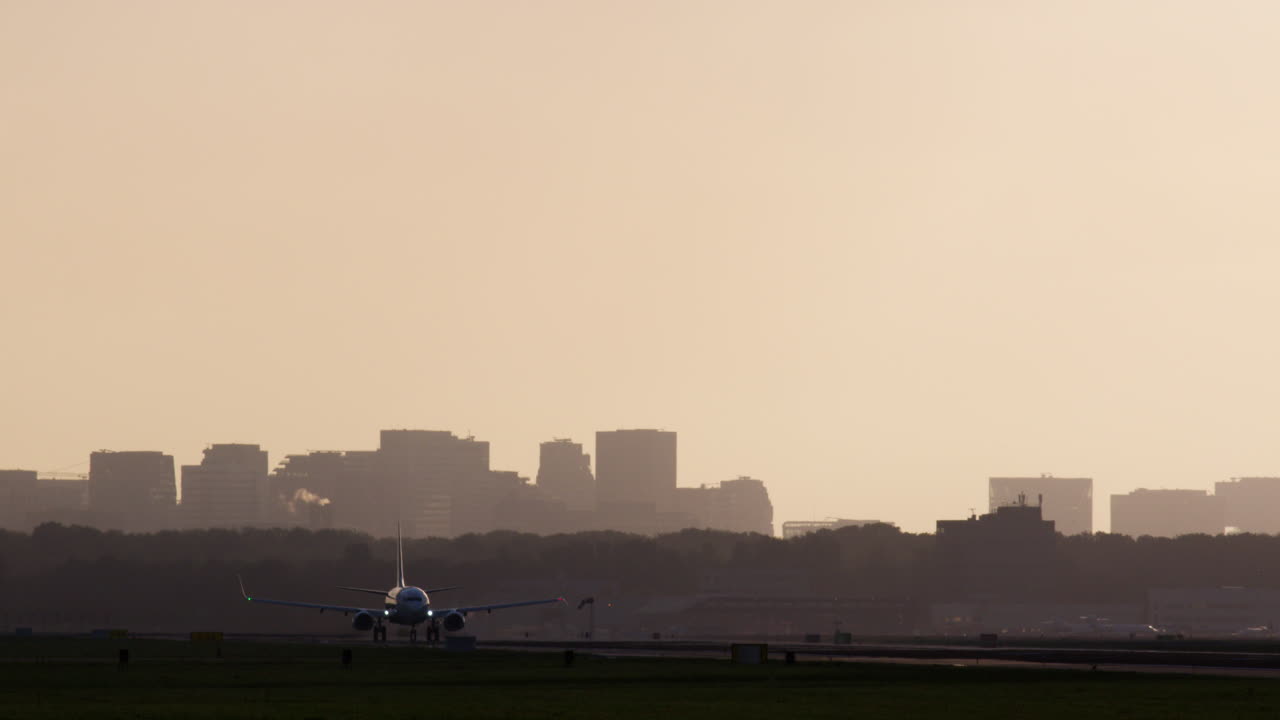 해가 지는 동안 도시 스카이 라인 위에서 이륙하는 비행기