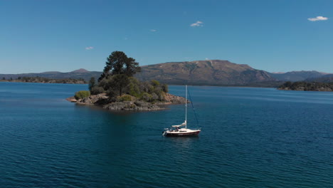 aerial - sailboat on beautiful hermoso lake, neuquen, argentina, spinning shot