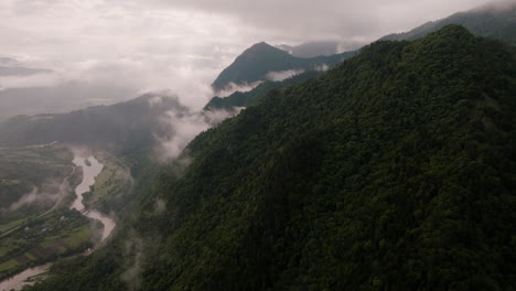 incline hacia arriba la toma aérea que revela un enorme nublado lluvioso que cubre las cumbres de las montañas