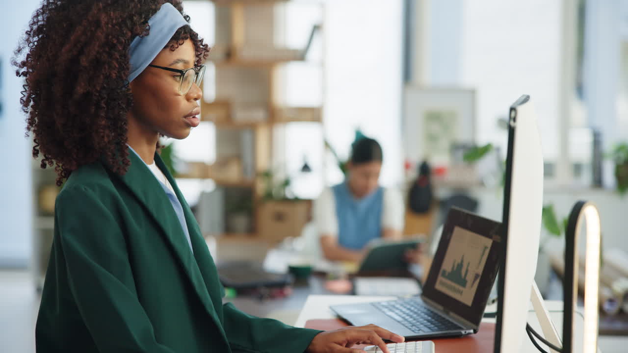Young African American Woman Working on Computer in Modern Office