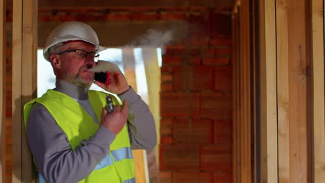 ingeniero civil arquitecto especialista hablando por teléfono móvil para controlar el trabajo en el sitio de construcción