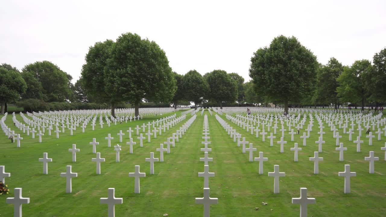 amplia toma en movimiento hacia atrás de filas de cruces blancas en el cementerio y memorial americano de los países bajos en margraten, holanda