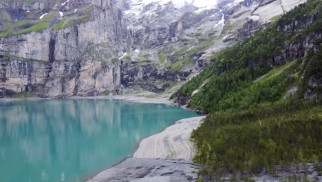 turquoise azure glacial alpine lake oeschinen surrounded by swiss blüemlisalp mountains in kandersteg, switzerland