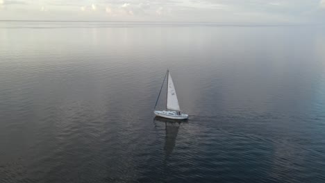 sailboat sailing on a cloudy day - aerial drone shot