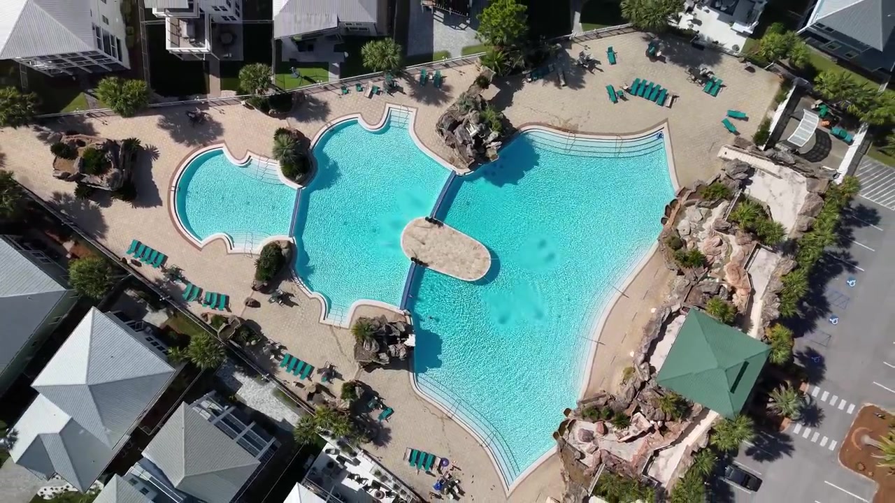 Ovenfra-udsigt af swimmingpool og ferieboliger på en solrig dag. - stigende luftoptagelse.