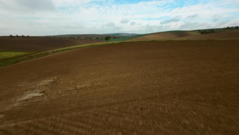 Fast-FPV-drone-shot-cruising-over-farming-grounds-in-Czech-republic