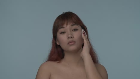 woman applying facial cotton