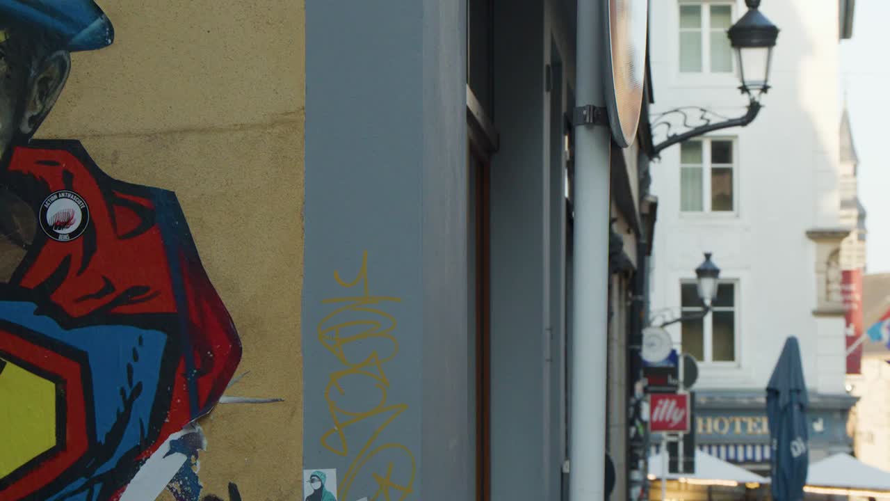 A detailed view of colorful graffiti on a building wall overlooking a narrow urban street