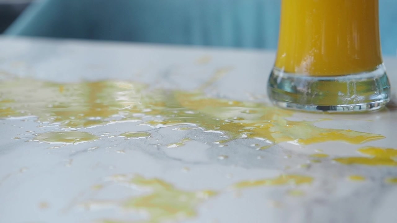 Jugo de naranja derramado sobre una mesa de mármol