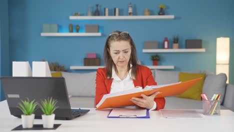 trabajadora de oficina en casa revisando archivos de papeleo.
