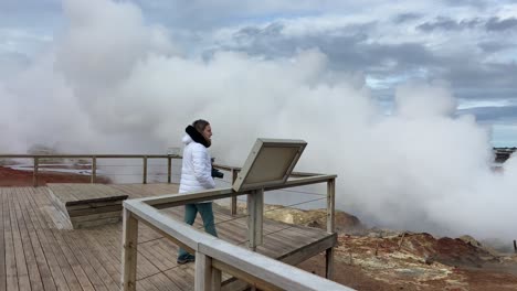 Tourist-girl-walking-on-the-wooden-platform-of-Gunnuhver-volcanic-area-in-Iceland