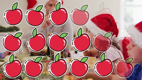 animación de manzanas sobre familia caucásica con sombreros de santa teniendo cena de navidad.