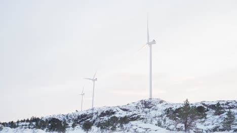 wind turbines against cloudy sky in bessaker, norway in winter - wide shot