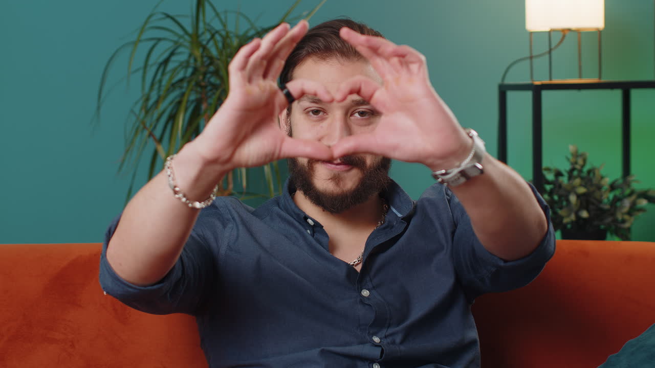 Happy lebanese man guy makes symbol of love showing heart sign to camera express romantic feelings