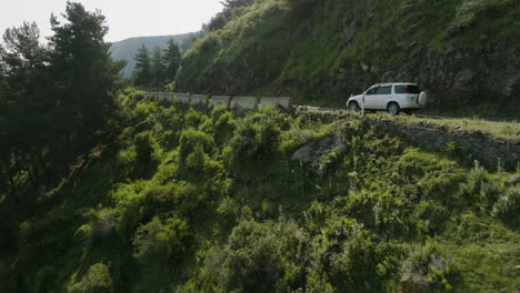 car driving through winding, mountain road - shot revealing dreamy landscape