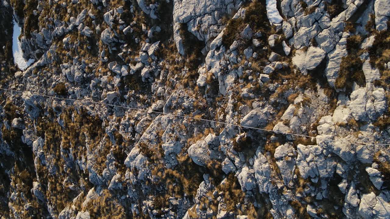 Top-down view of man trekking irregular rocky trail, Sveti Jure, Park prirode Biokovo.