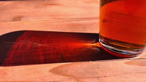 pint of beer with shadow on wooden table