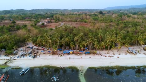 aerial reveal of busy paliton beach at sunset, siquijor, visayas, philippines