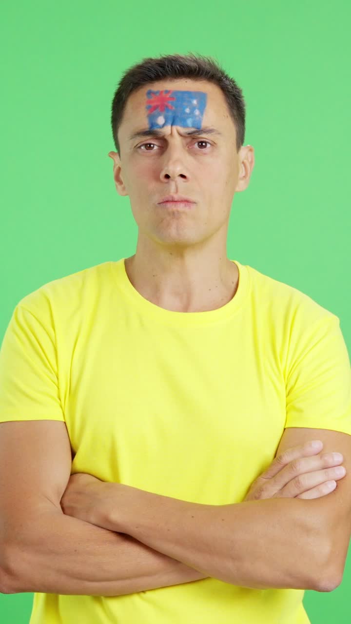 Dignified and serious man with australian flag painted on face