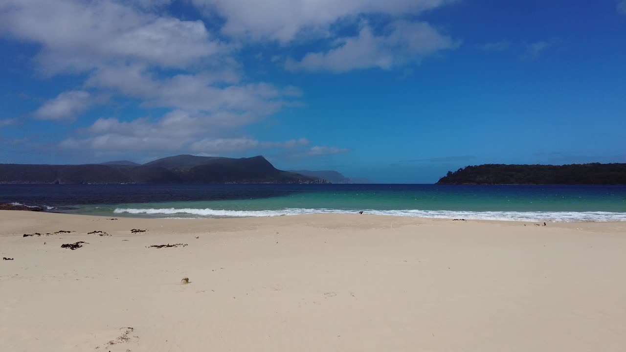 toma panorámica de cielo azul y nubes con arena blanca en la cala de seguridad en port arthur, tasmania