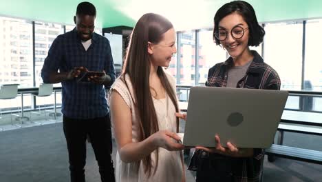 mujeres ejecutivas que usan computadoras portátiles mientras que los hombres ejecutivos usan tabletas digitales 4k