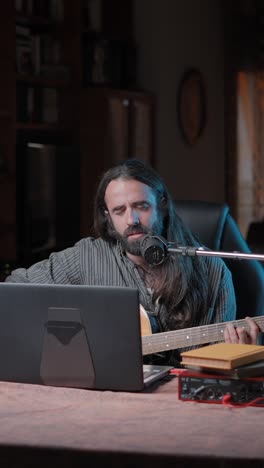 musician recording acoustic guitar in home studio