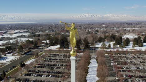 angel moroni statue on lds mormon temple steeple in utah, aerial drone orbit