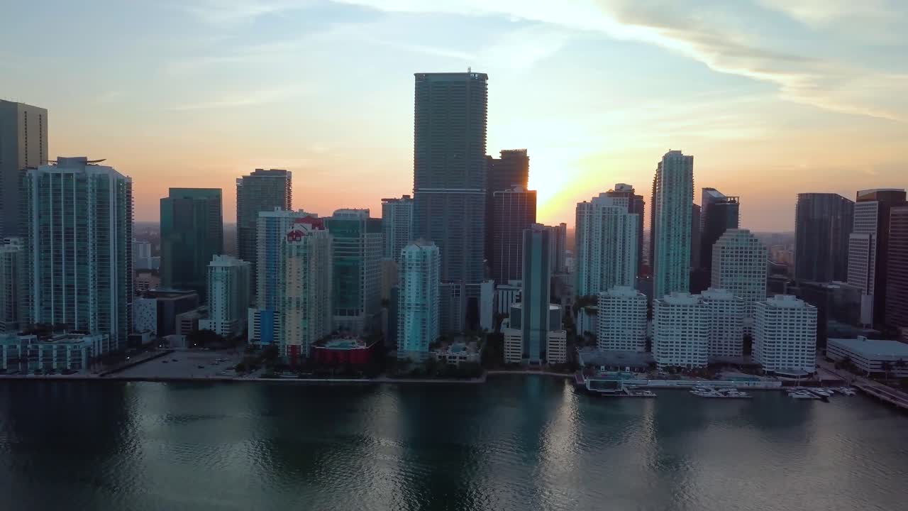 Vista aerea dell'alba, dietro grattacieli, nel quartiere di Brickell, in una mattina di sole, a Miami, Florida, USA - inquadratura in movimento, ripresa con drone.
