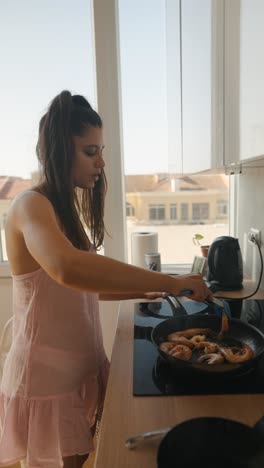 mujer cocinando camarones en la cocina