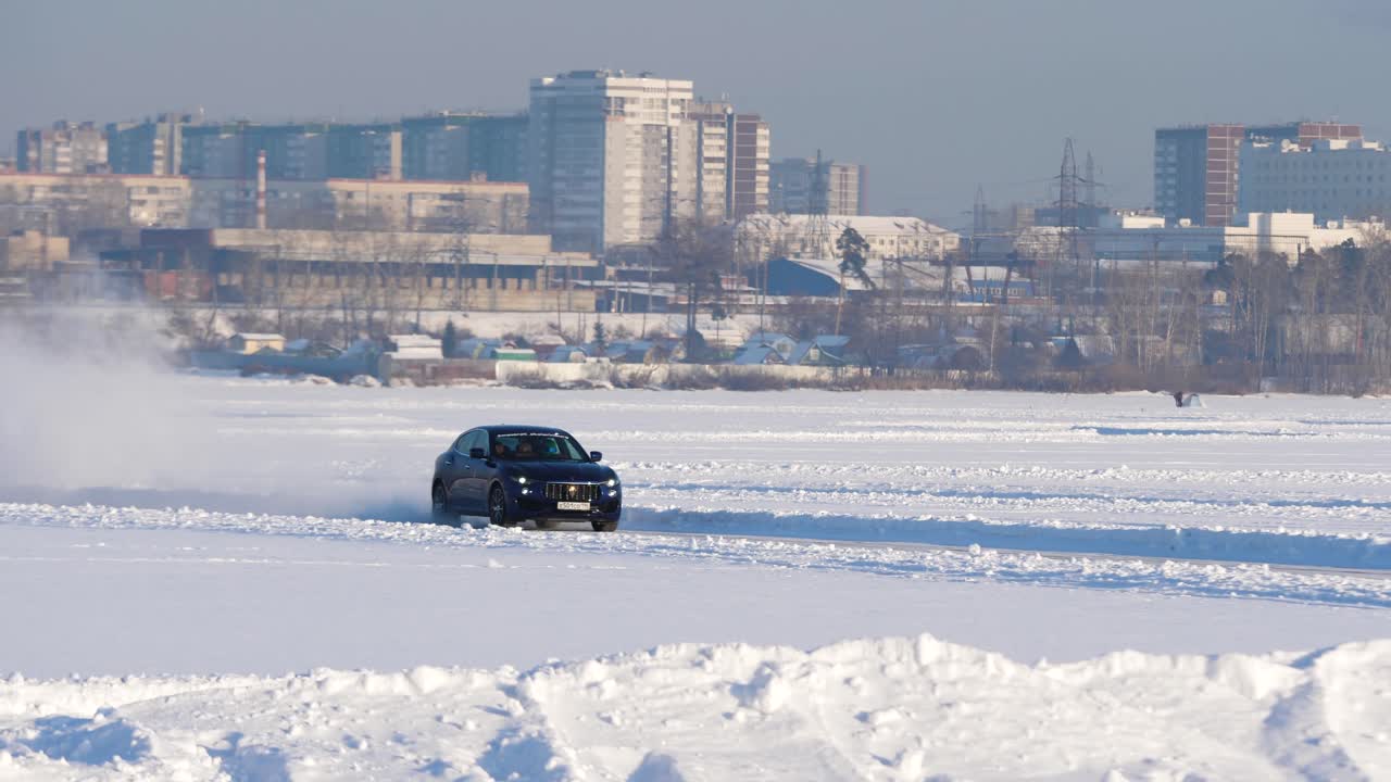 얼어붙은 강에서 운전하는 어두운 파란색 자동차