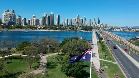 australian flag waving in the breeze near a park and roadway