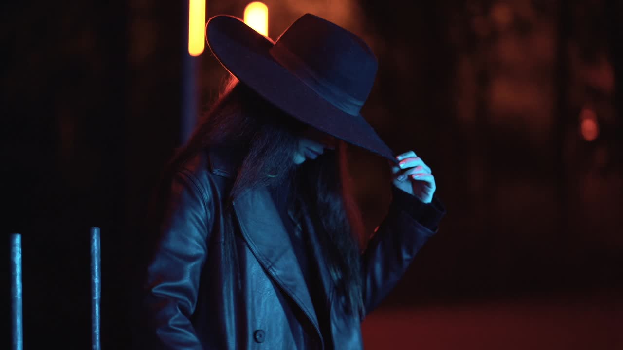 Donna con cappello e giacca di pelle di notte