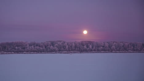 Day-to-night-timelapse-of-yellow-setting-sun-over-snowy-landscape-at-sunset