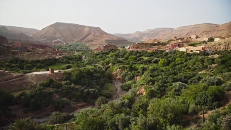 Beautiful-green-oasis-in-middle-of-valley-from-Atlas-Mountain-range,-pan-right