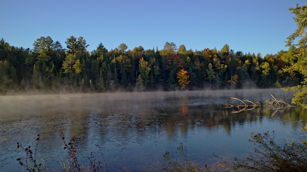 Cinematic scenic nature shot of the Au Sable River at sunrise with mist