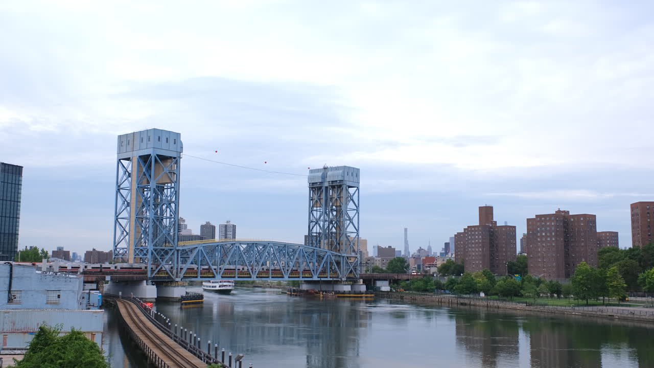 뉴욕시 브롱크스와 할렘 맨해튼 사이에 있는 할렘 강 아래를 관광 보트가 지나갈 때 파크 애비뉴 다리를 지나는 통근 열차의 고정 지상 사진