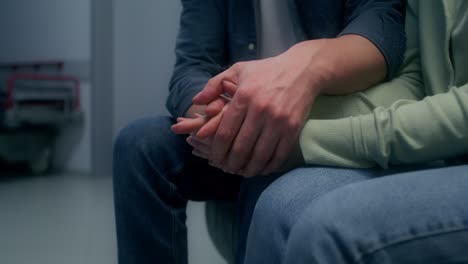 couple holding hands in a hospital waiting room