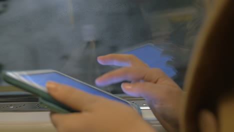 tableta en manos de un pasajero del metro