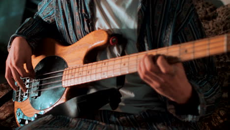 man plays the bass guitar while shifting focus