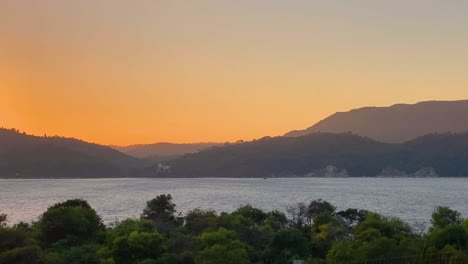 Hermosa-Vista-Panorámica-A-Través-De-Las-Montañas-En-El-Cielo,-Emerge-Una-Espectacular-Puesta-De-Sol-De-Luz-Naranja