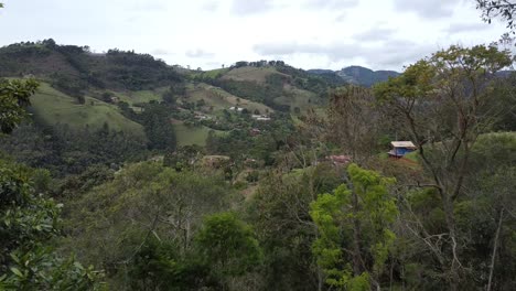 Drone-Pasando-Cerca-De-Algunos-árboles-Con-Cámara-Descendiendo-Y-Revelando-Una-Hermosa-Cascada-En-Medio-De-La-Naturaleza