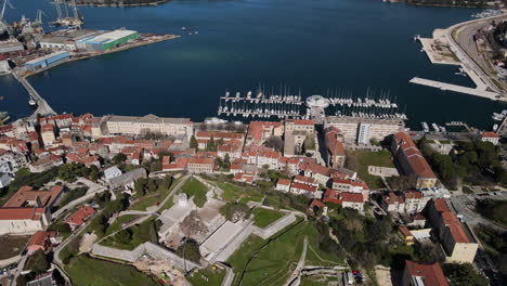 aerial of pula harbor in croatia, old roman forum with boats docked