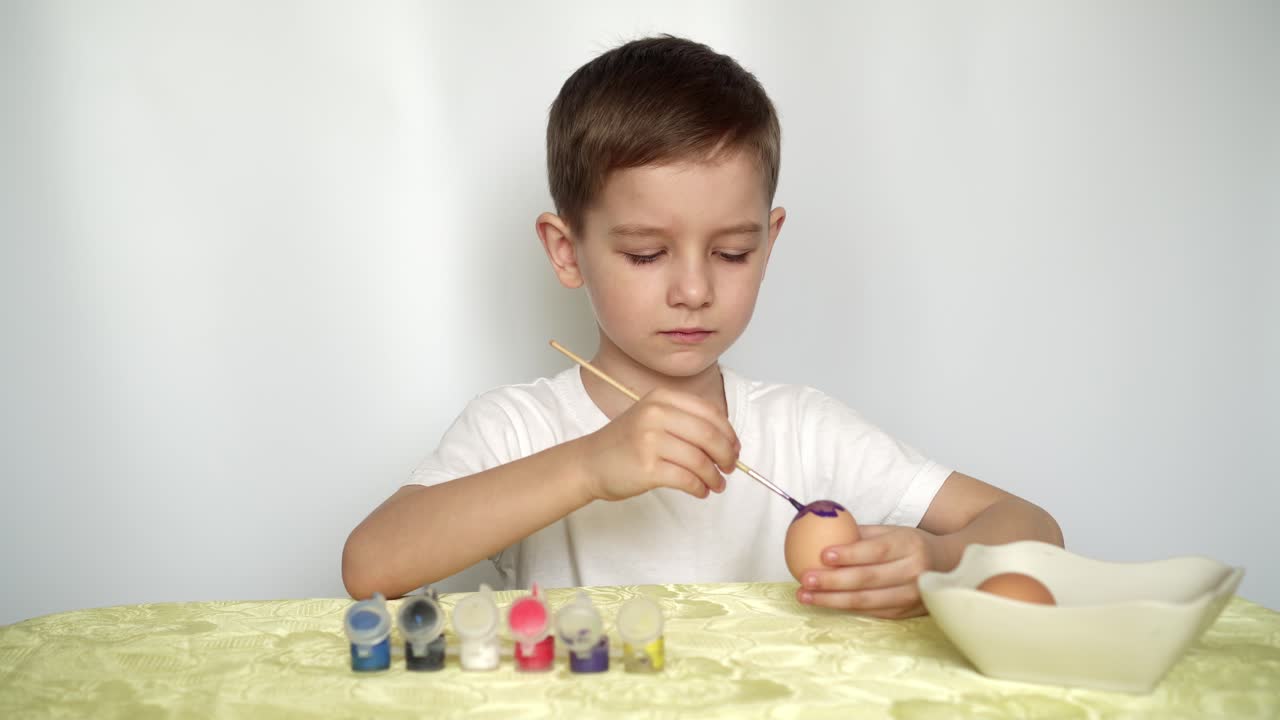 Buona Pasqua. Un bel bambino caucasico dipinge e decora le uova 01