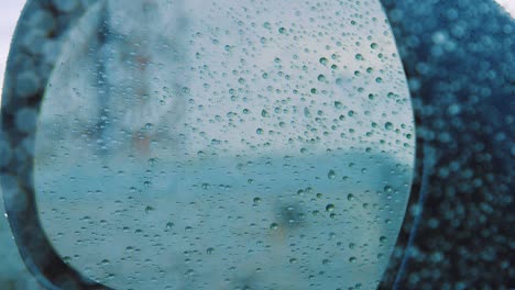 Un-Espejo-Lateral-Borroso-De-Un-Coche-Cubierto-De-Gotas-De-Lluvia---Cerrar